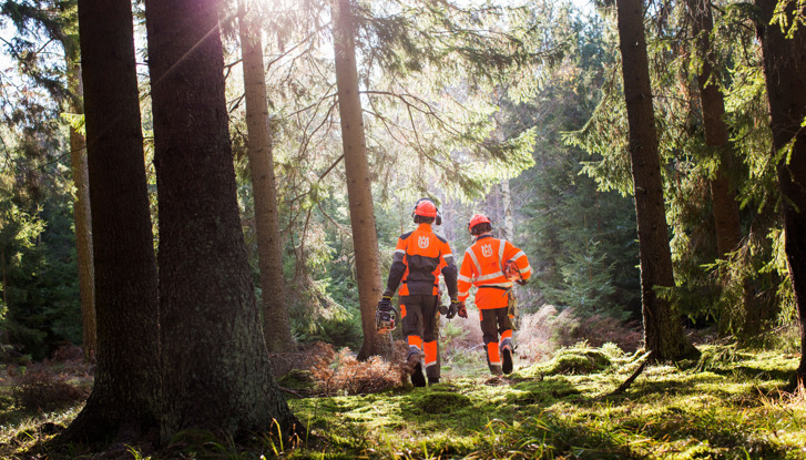 Deux hommes en combinasion orange dans une forêt.