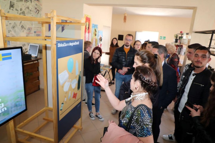 Photo of Ambassodor Elsa Håsatd pointing at the exhibition posters